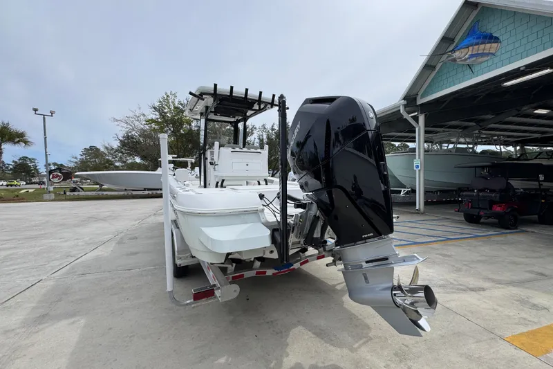 Slide: The Image of 2026 Caymas 26 HB boat with powerful outboard motor on a trailer in a marina. - 14