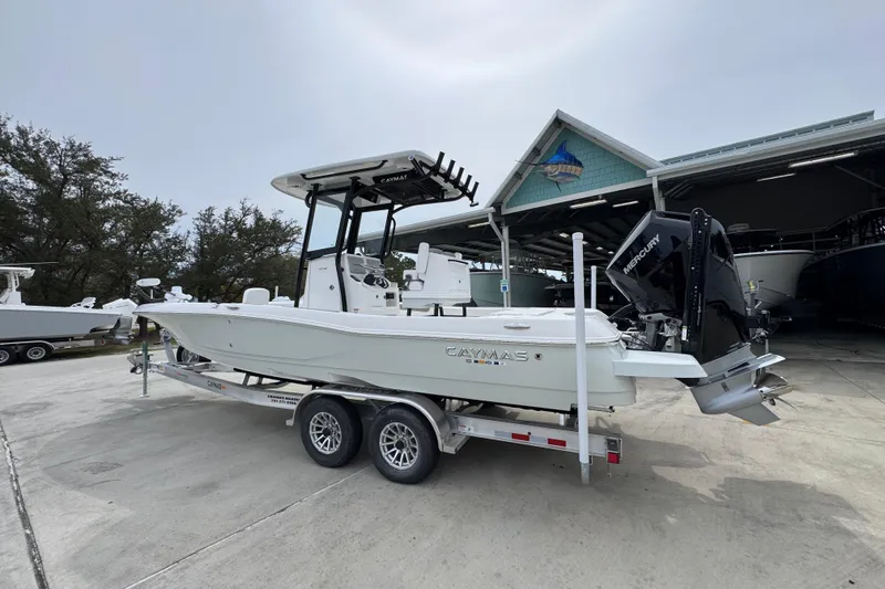 Slide: The Image of 2026 Caymas 26 HB boat on trailer, parked outdoors near a marina. - 16