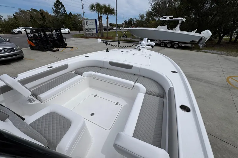Slide: The Image of 2026 Caymas 26 HB boat with spacious seating and modern design in a parking area. - 17