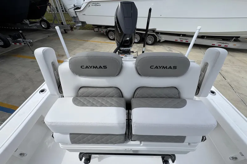 Slide: The Image of 2026 Caymas 26 HB boat seating with gray and white upholstery, parked on a trailer. - 29