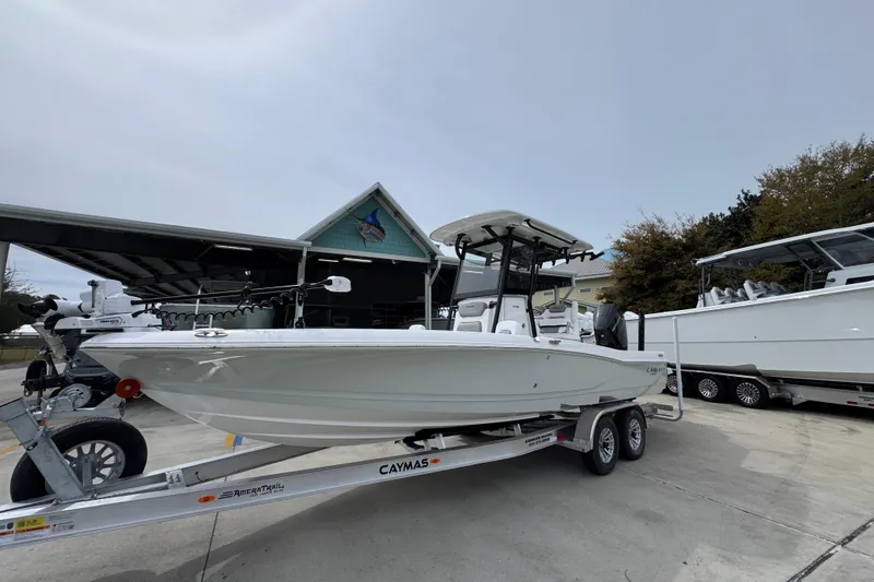 Slide: The Image of 2026 Caymas 26 HB boat on trailer, displayed outdoors near a building. - 3