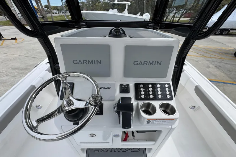 Slide: The Image of 2026 Caymas 26 HB boat dashboard with dual Garmin displays and steering wheel. - 33