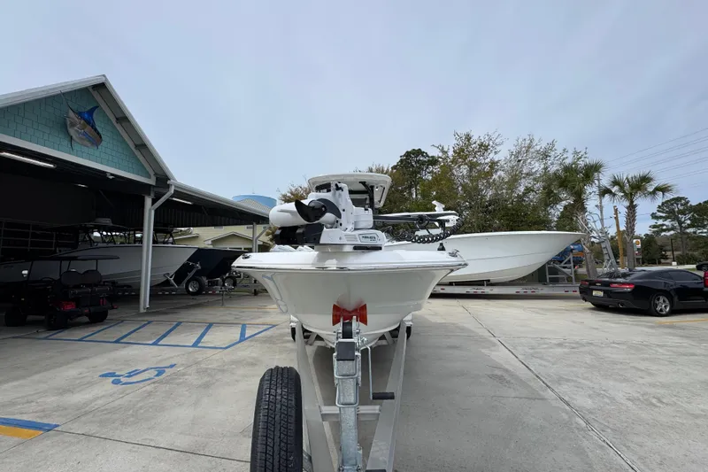 Slide: The Image of 2026 Caymas 26 HB boat on trailer at marina, surrounded by other boats and vehicles. - 6