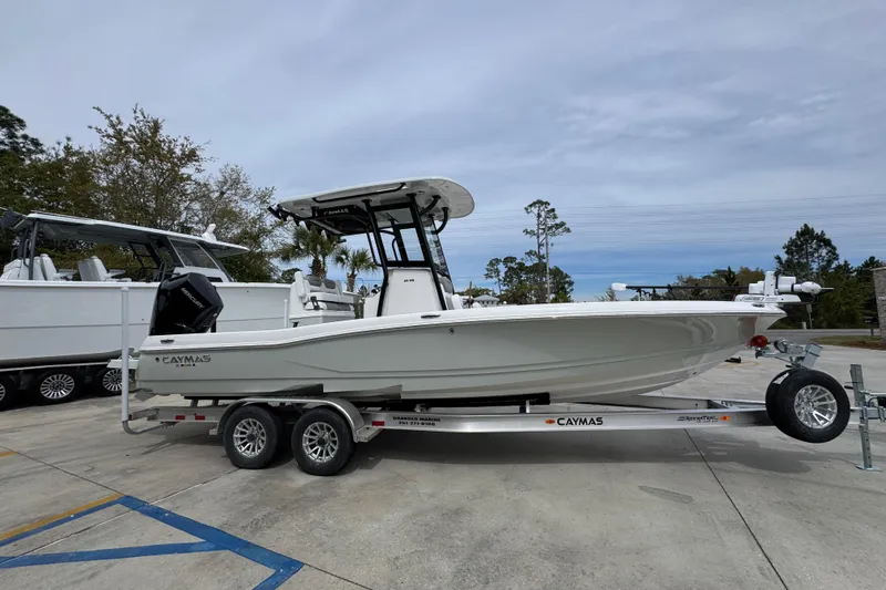 Slide: The Image of 2026 Caymas 26 HB boat on trailer, parked outdoors, side view. - 9