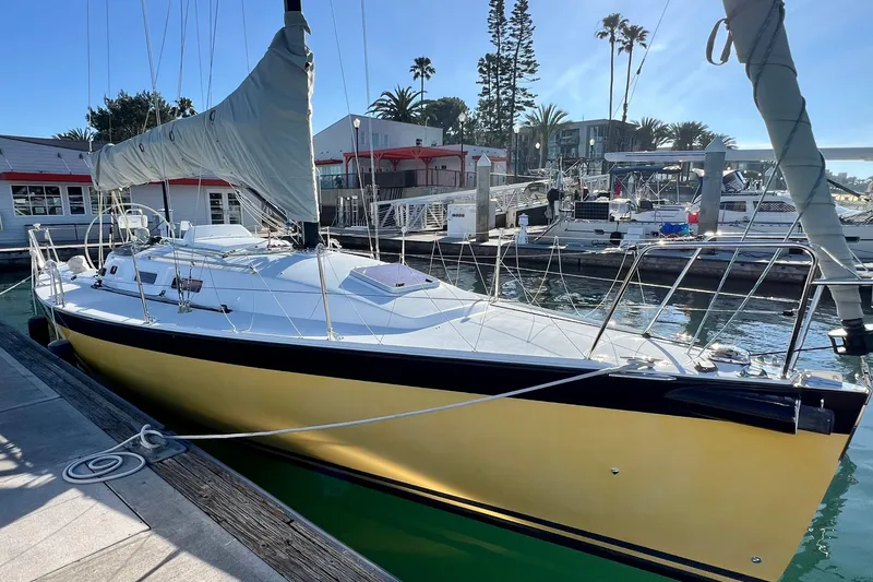 Slide: The Image of 2003 J Boats J/109 sailboat docked at a marina, featuring a sleek yellow hull. - 14