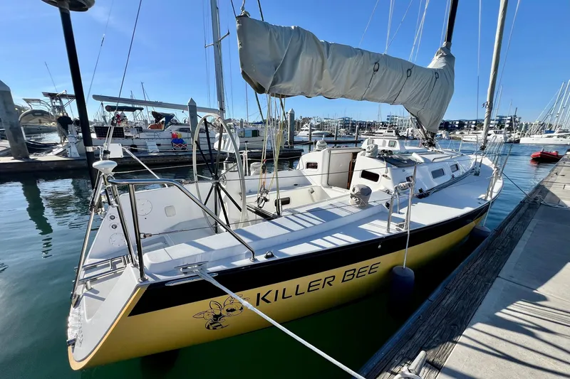 Slide: The Image of 2003 J Boats J/109 sailboat named "Killer Bee" docked at a marina. - 15