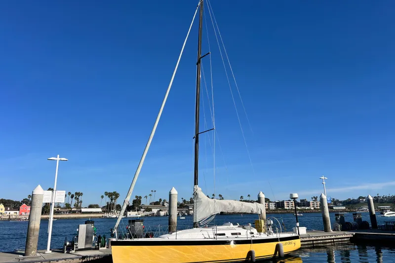 Slide: The Image of Yellow 2003 J Boats J/109 sailboat docked at marina under clear blue sky. - 2