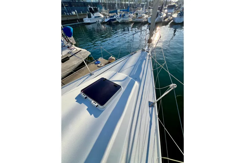 Slide: The Image of 2003 J Boats J/109 sailboat deck with marina view, showcasing sleek design and sunlight reflections. - 38