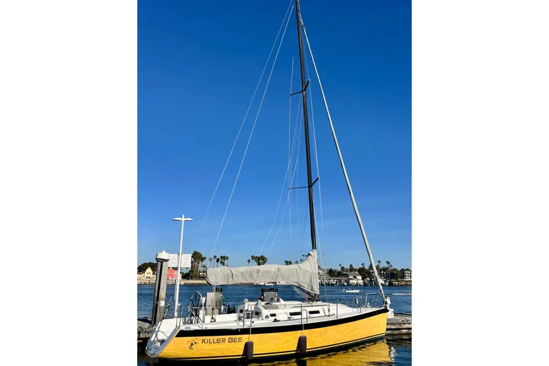 Slide: The Image of Yellow 2003 J Boats J/109 sailboat docked under clear blue sky. - 5