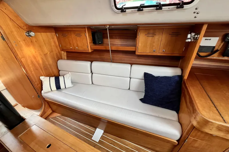 Slide: The Image of Interior of 2003 J Boats J/109 sailboat with wooden cabinetry and cushioned seating. - 59