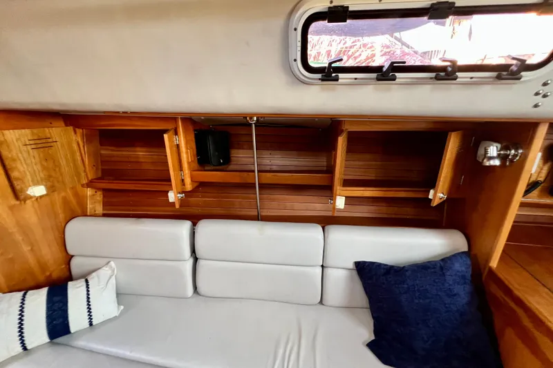 Slide: The Image of Interior of 2003 J Boats J/109 sailboat with wooden cabinets and cushioned seating. - 60