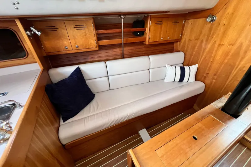 Slide: The Image of Interior of 2003 J Boats J/109 sailboat with wooden cabinetry and cushioned seating. - 61