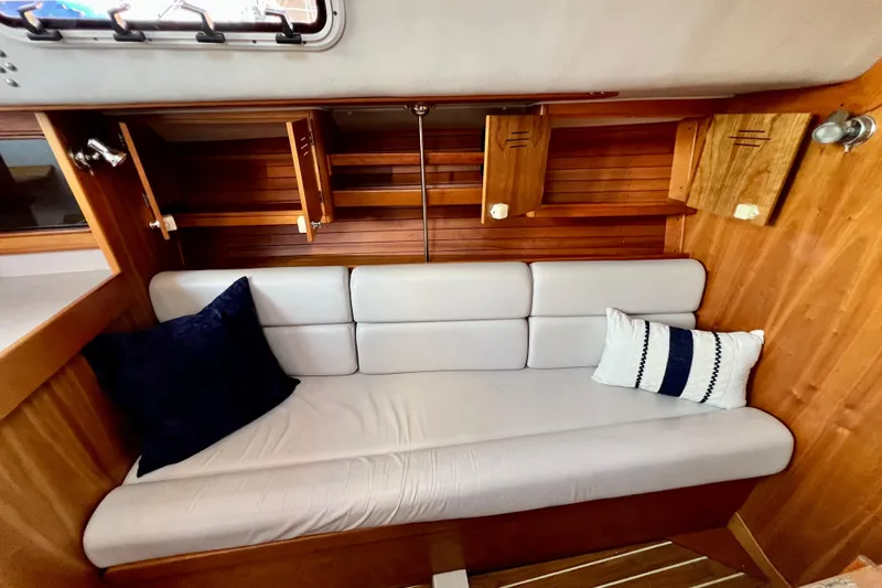 Slide: The Image of Interior of 2003 J Boats J/109 sailboat with cushioned seating and wooden cabinetry. - 62