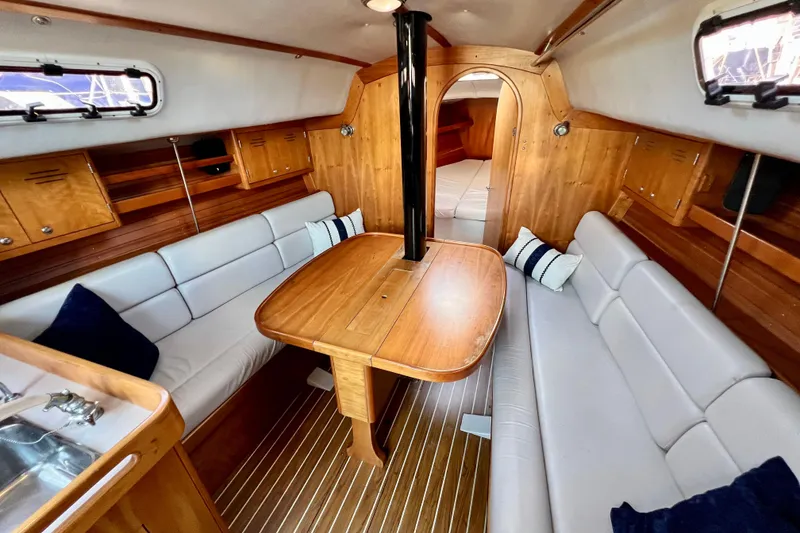 Slide: The Image of Interior of 2003 J Boats J/109 sailboat with cozy seating and wooden finishes. - 63