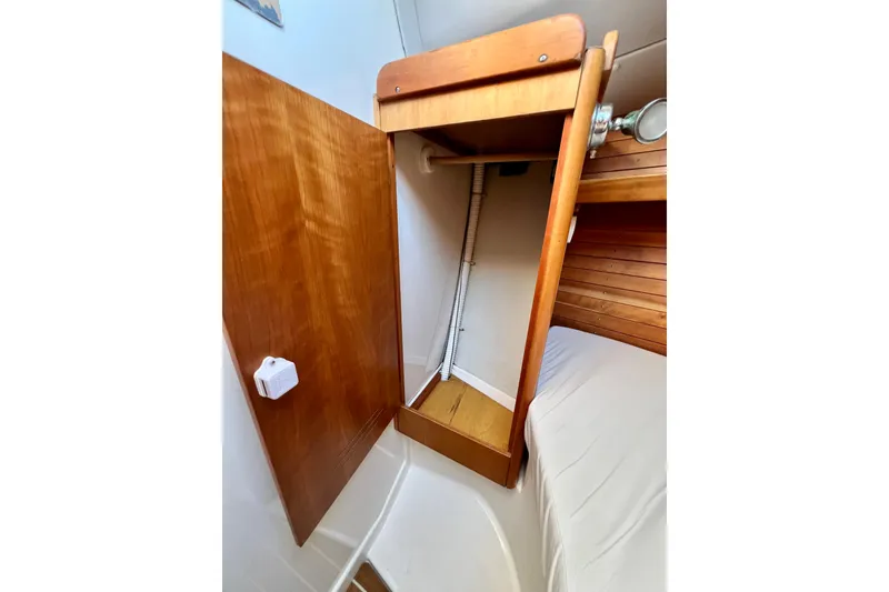 Slide: The Image of Interior of 2003 J Boats J/109 sailboat, featuring wooden cabinetry and cozy sleeping area. - 68