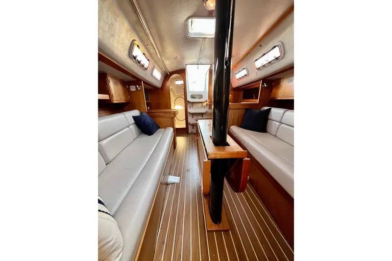 Slide: The Image of Interior of 2003 J Boats J/109 sailboat with wood flooring and cushioned seating. - 73