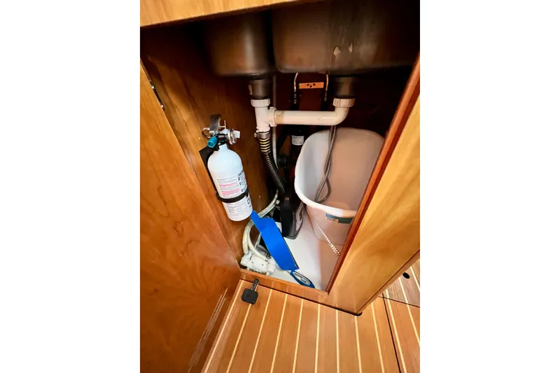 Slide: The Image of Interior view of 2003 J Boats J/109 cabinet with plumbing and fire extinguisher. - 77