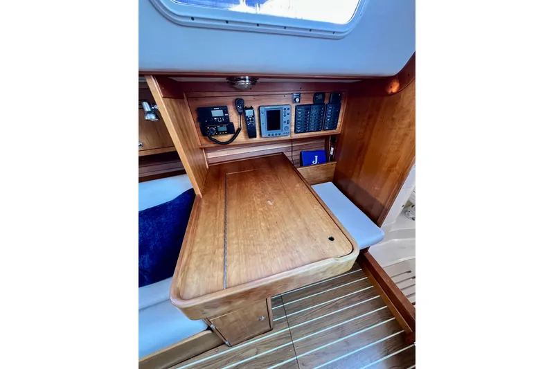 Slide: The Image of Interior of 2003 J Boats J/109 sailboat with navigation station and wooden table. - 78