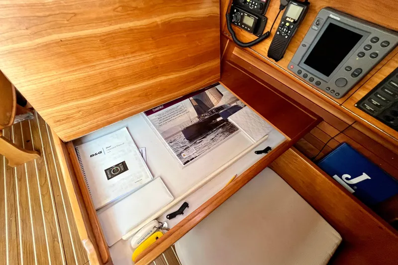 Slide: The Image of Navigation station of a 2003 J Boats J/109 with manuals and equipment. - 79