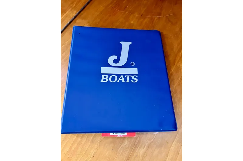 Slide: The Image of Blue J Boats folder on wooden surface, related to 2003 J/109 model. - 82