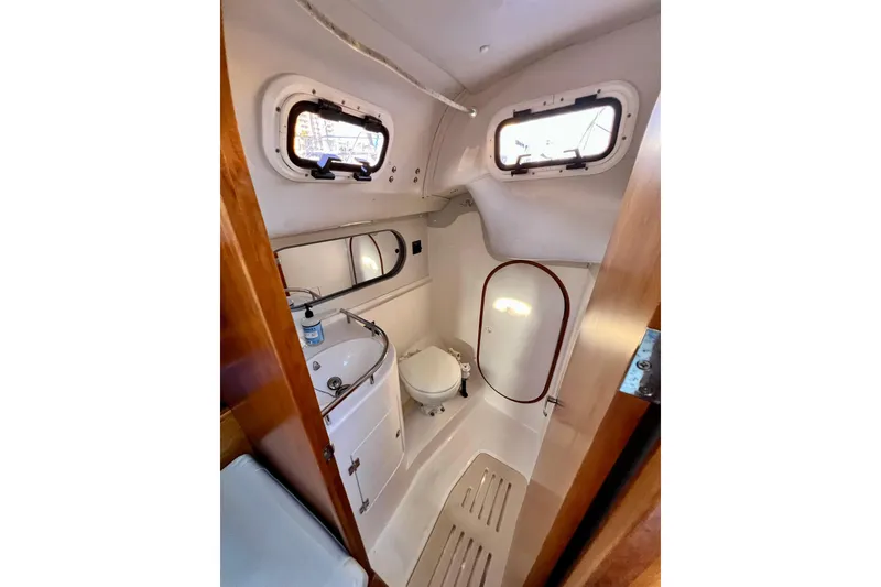 Slide: The Image of Compact bathroom in 2003 J Boats J/109 sailboat with sink, toilet, and portholes. - 89