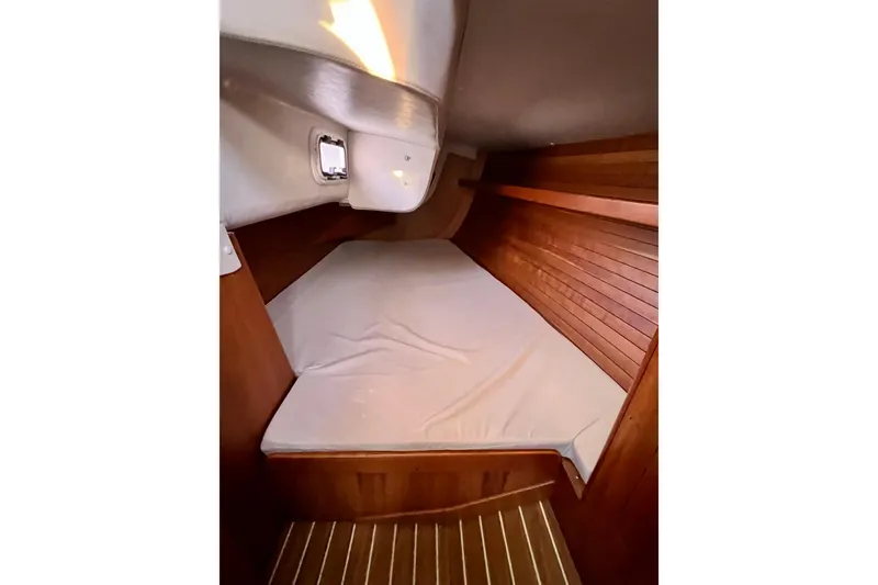 Slide: The Image of Cozy cabin interior of 2003 J Boats J/109 with wooden paneling and mattress. - 91