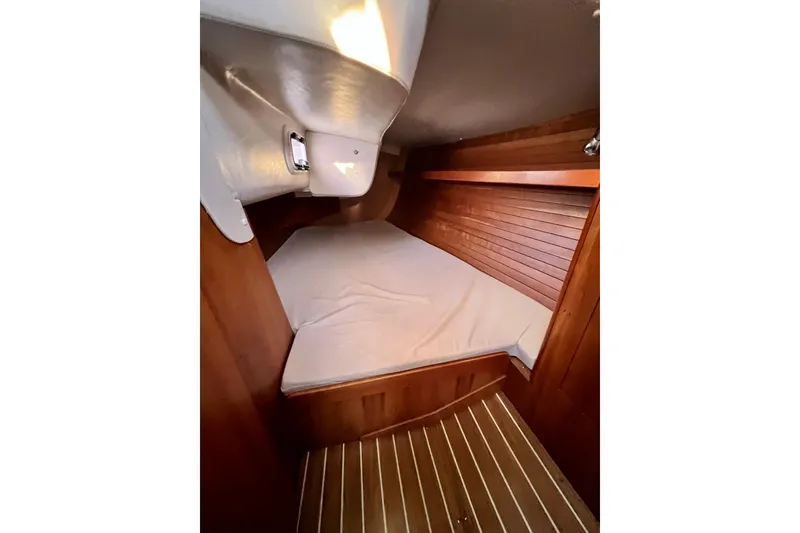 Slide: The Image of Cozy cabin interior of 2003 J Boats J/109 with wooden paneling and mattress. - 92