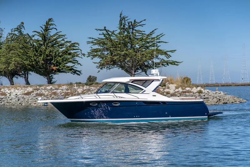 Slide: The Image of 2012 Tiara Yachts 3100 Coronet on calm water near trees. - 4