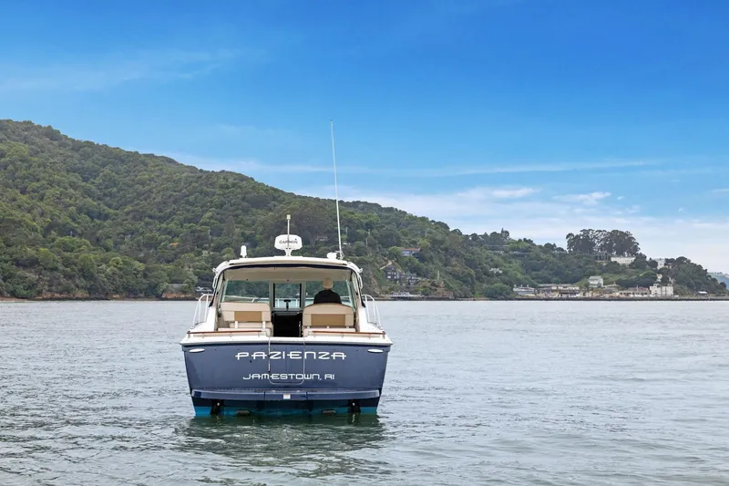 Slide: The Image of 2012 Tiara Yachts 3100 Coronet on serene water with lush green hills in the background. - 50