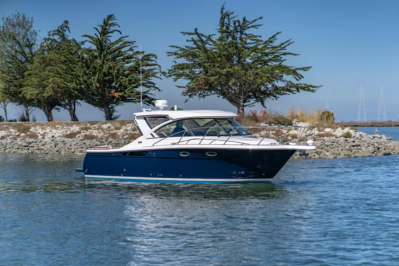 Slide: The Image of 2012 Tiara Yachts 3100 Coronet on calm water near trees. - 6