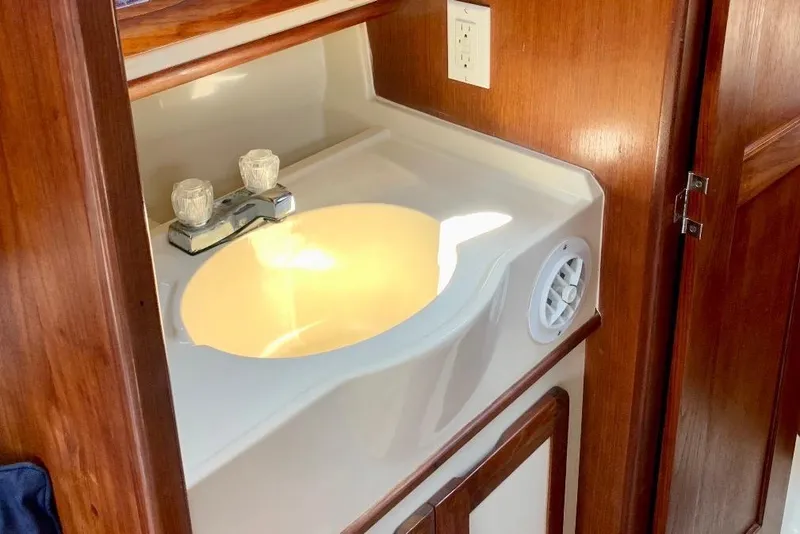 Slide: The Image of 1993 Hunter 33.5 yacht bathroom sink with wooden cabinetry and modern fixtures. - 57