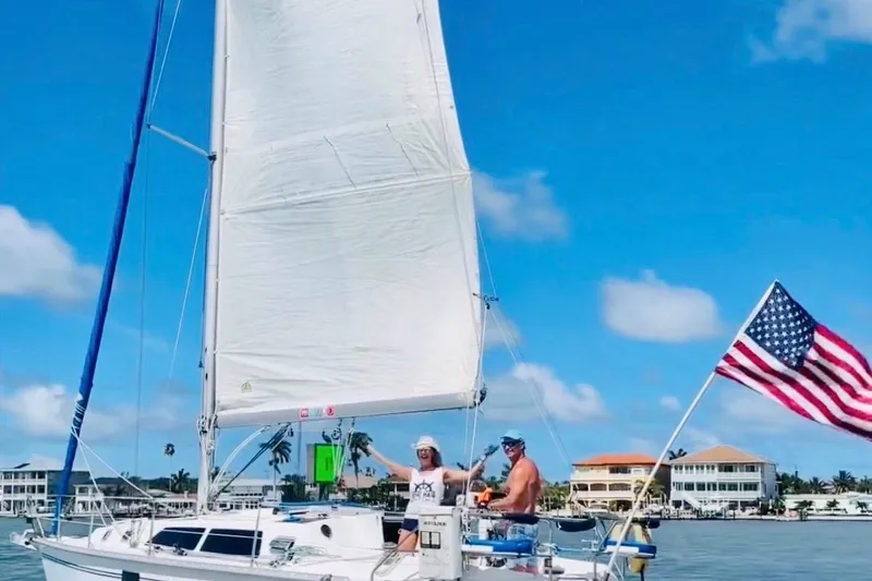 Slide: The Image of Sailing on a 1993 Hunter 33.5 yacht with American flag, clear blue sky. - 63