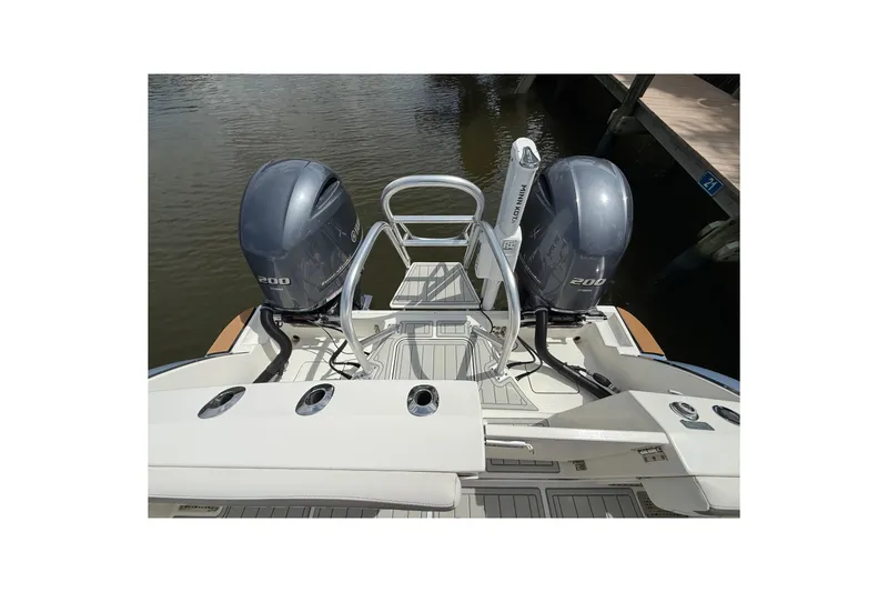 Slide: The Image of 2021 World Cat 280 CC-X boat with dual 200 horsepower engines, docked on calm water. - 10