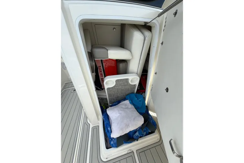 Slide: The Image of Storage compartment in a 2021 World Cat 280 CC-X boat with life jackets and gear. - 16