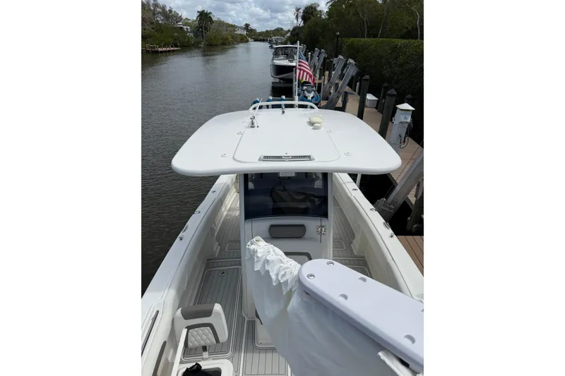 Slide: The Image of 2021 World Cat 280 CC-X boat docked on a calm river with lush greenery. - 18