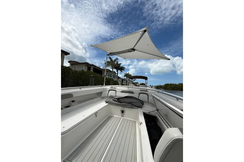 Slide: The Image of 2021 World Cat 280 CC-X boat with canopy, docked under a partly cloudy sky. - 27