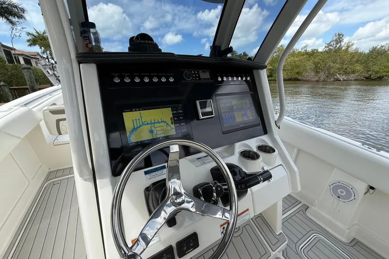 Slide: The Image of 2021 World Cat 280 CC-X boat dashboard with navigation screens and steering wheel. - 5
