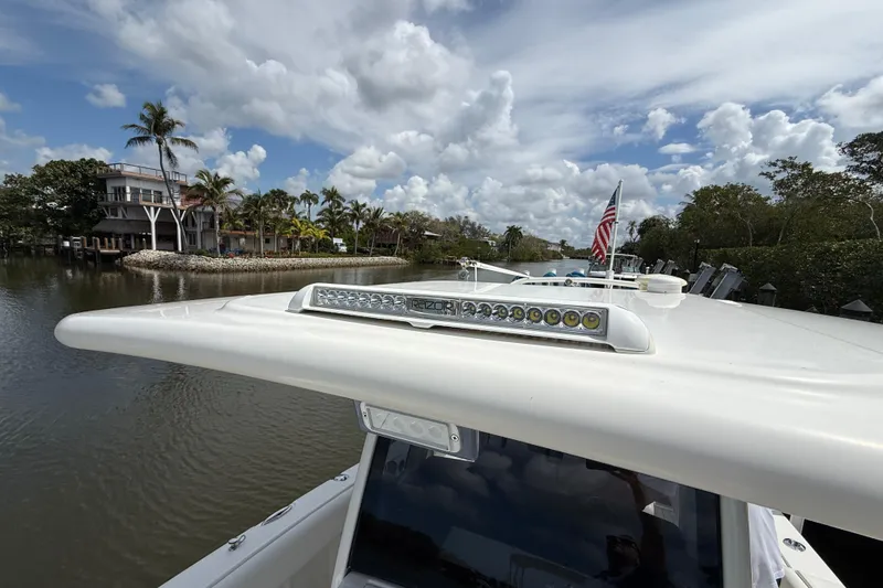 Slide: The Image of 2021 World Cat 280 CC-X boat with LED lights, American flag, and scenic waterfront view. - 8