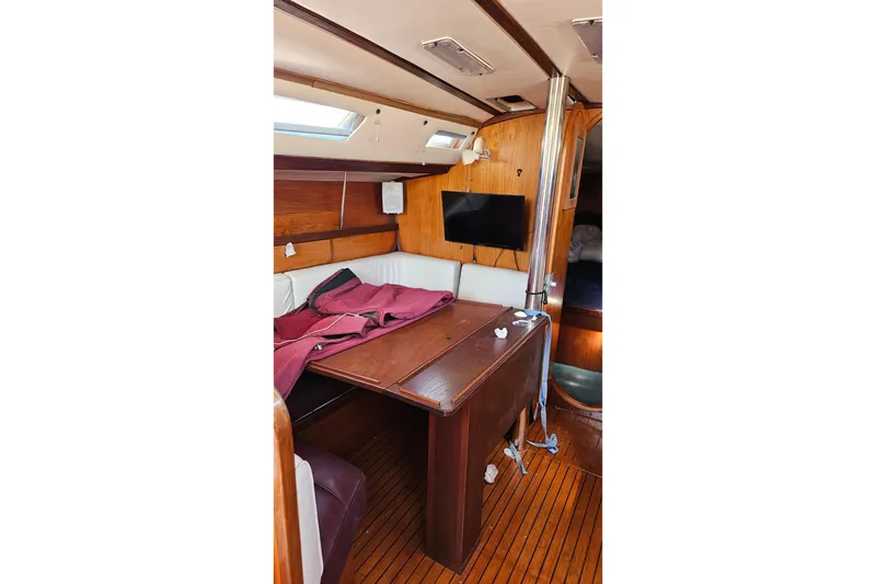Slide: The Image of Interior of 1989 Gib'Sea 37 sailboat with wooden table and seating area. - 24
