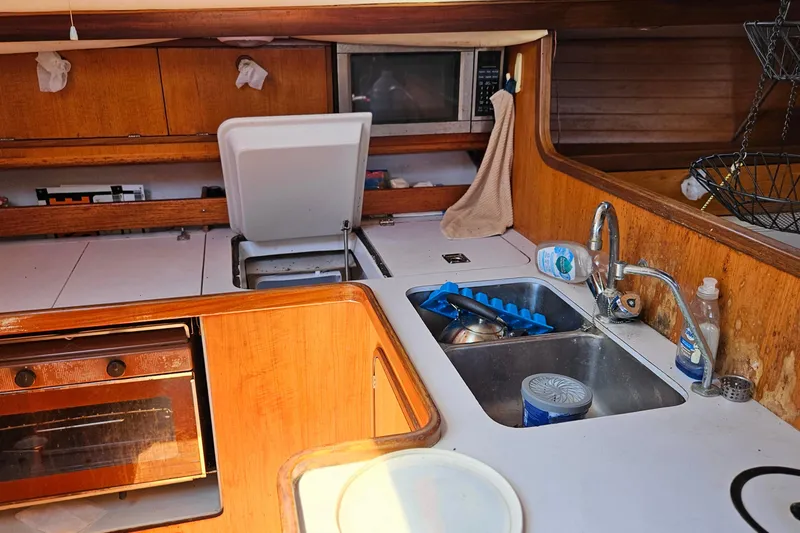 Slide: The Image of Galley kitchen in 1989 Gib'Sea 37 sailboat with sink, stove, and microwave. - 26