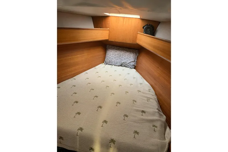 Slide: The Image of Cozy cabin interior of 1989 Gib'Sea 37 sailboat with wooden paneling and patterned bedding. - 27
