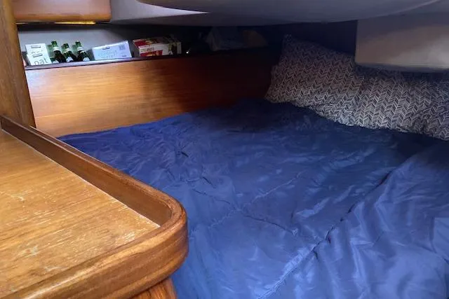 Slide: The Image of Cozy cabin interior of 1989 Gib'Sea 37 sailboat with blue bedding and wooden accents. - 32