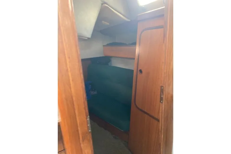 Slide: The Image of Interior cabin of 1989 Gib'Sea 37 sailboat with wooden paneling and green seating. - 36