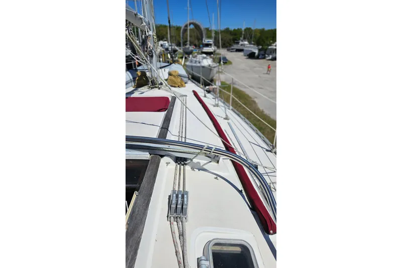 Slide: The Image of 1989 Gib'Sea 37 sailboat deck with rigging and red accents in a marina. - 9