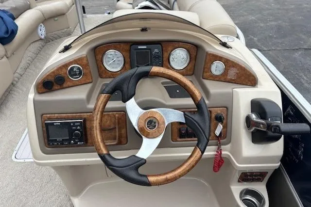 Slide: The Image of Steering console of a 2011 Berkshire 243 SLX boat with wood accents and gauges. - 8