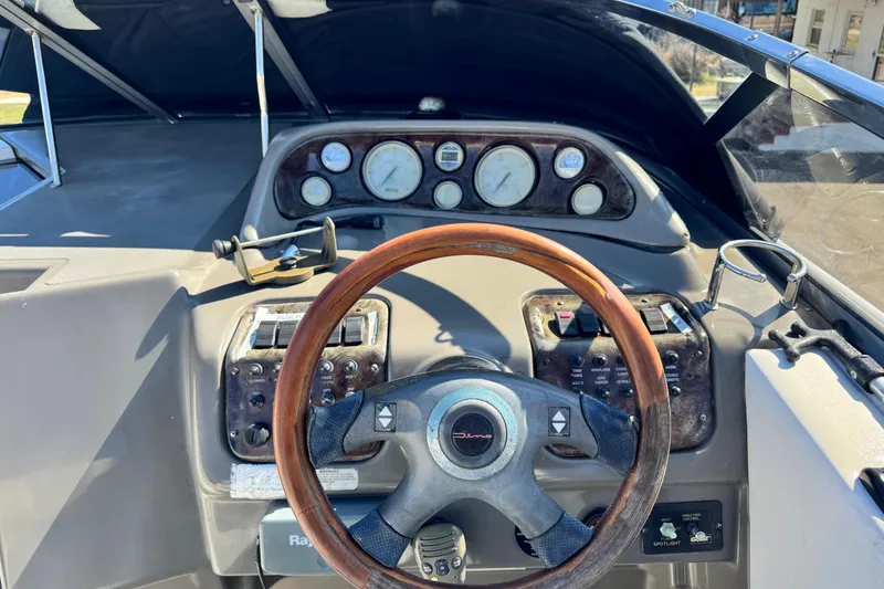 Slide: The Image of Steering console of a 2007 Regal Commodore 2665 boat with wooden wheel and gauges. - 22