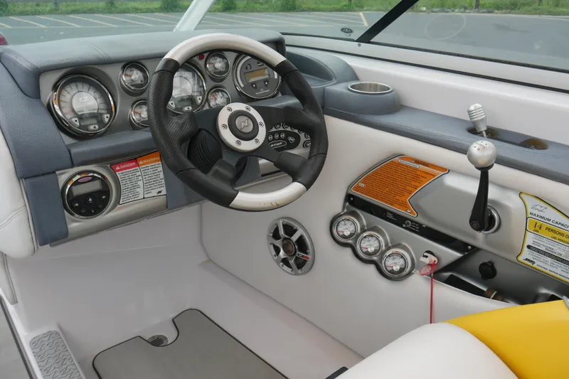 Slide: The Image of 2007 Correct Craft 236 Team Edition boat dashboard with steering wheel and control gauges. - 11