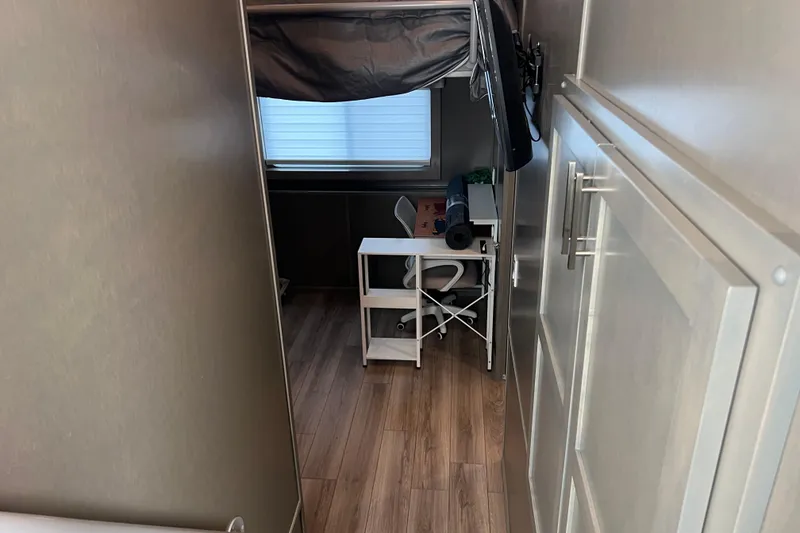 Slide: The Image of Interior of 2026 Sumerset Luxe II houseboat with wooden flooring and compact workspace. - 14