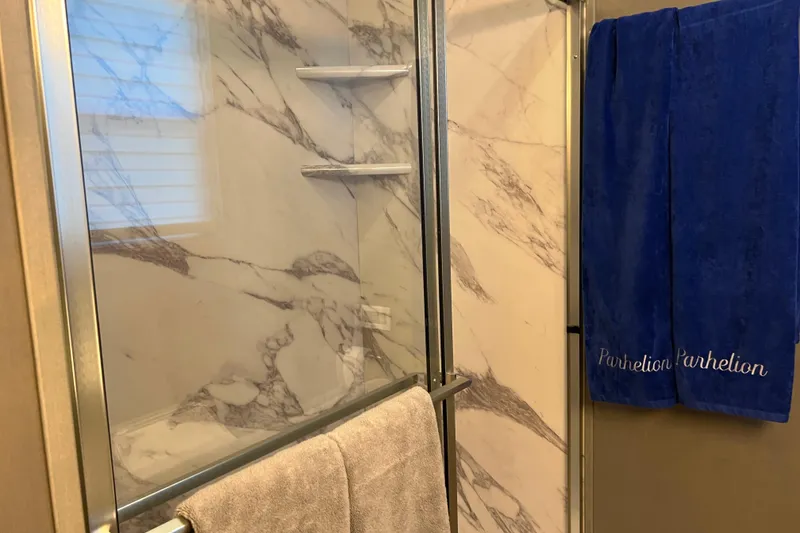 Slide: The Image of Luxurious Sumerset Luxe II 2026 bathroom with marble shower and blue embroidered towels. - 33