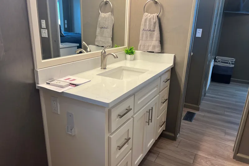 Slide: The Image of Modern bathroom vanity with white countertop, sleek faucet, and decorative towel in Sumerset Luxe II, 2026. - 34